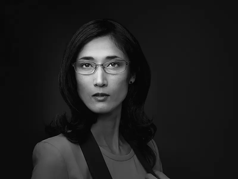 Black and white image of female wearing eyeglasses staring at the camera