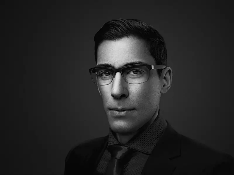 Black and white image of male wearing eyeglasses staring at the camera