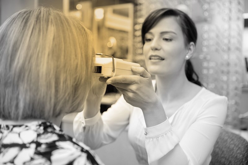 Female optician carrying out an eye examination on a female