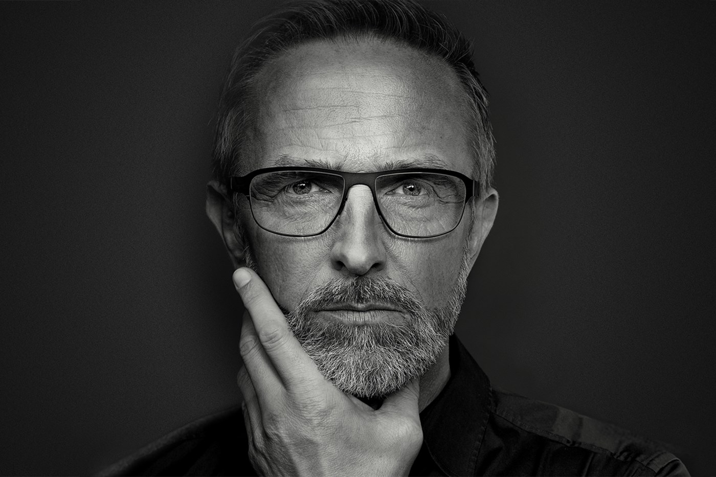 Black and white image of a male wearing eyeglasses looking away from the camera
