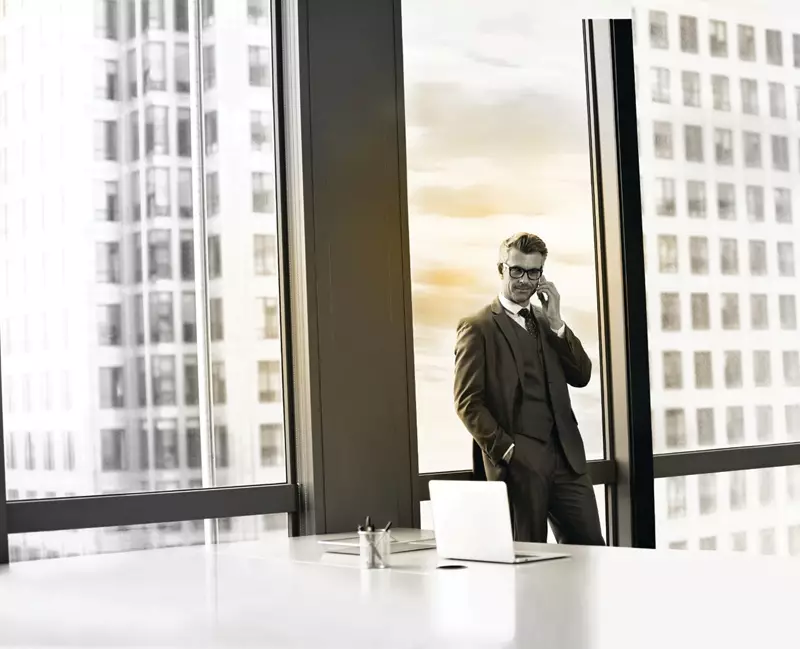 Male businessman wearing glasses on phonecall in office