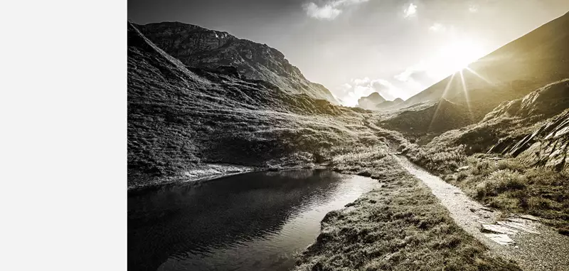 Image of mountain landscape with sun coming over the top