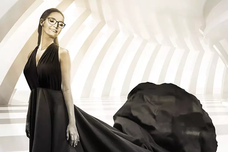 Female in black evening gown wearing glasses on bright backround