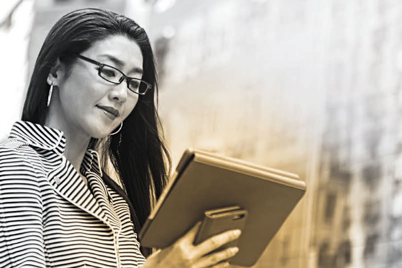 Female wearing eyeglasses using a tablet