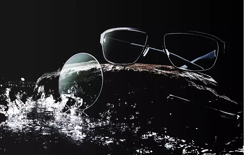 Glasses and lens on counter being splashed with water