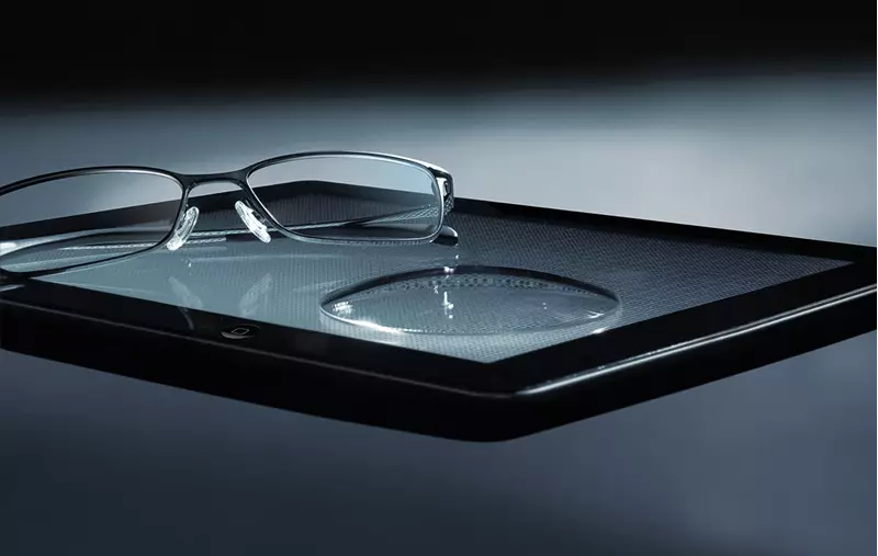Eyeglasses sat on a tablet with lens
