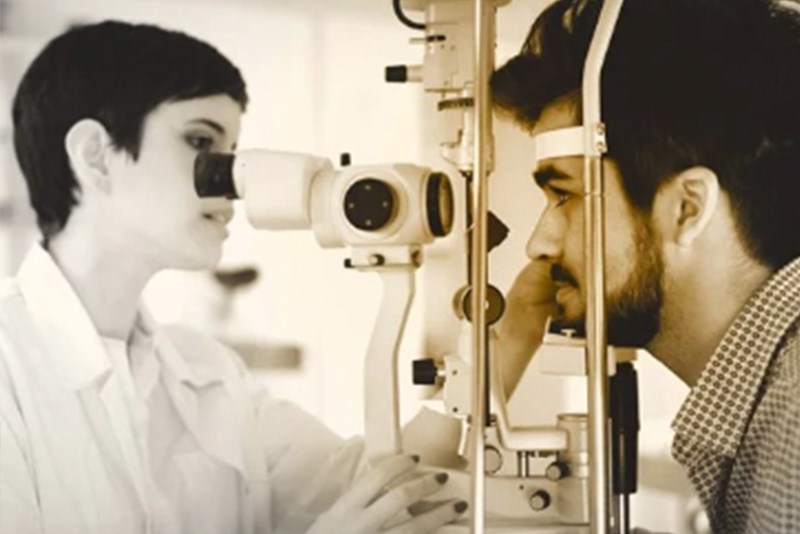 Female optician conducting an eye examination on a male
