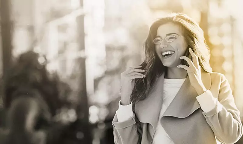 Female wearing eyeglasses on phone call smiling