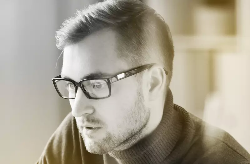 Male wearing eyeglasses focused on something
