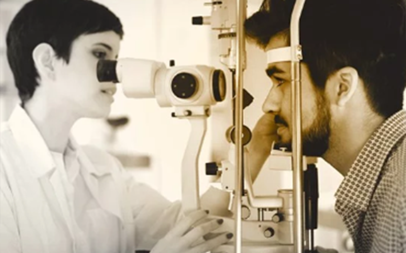 Female optician conducting eye examination on a male