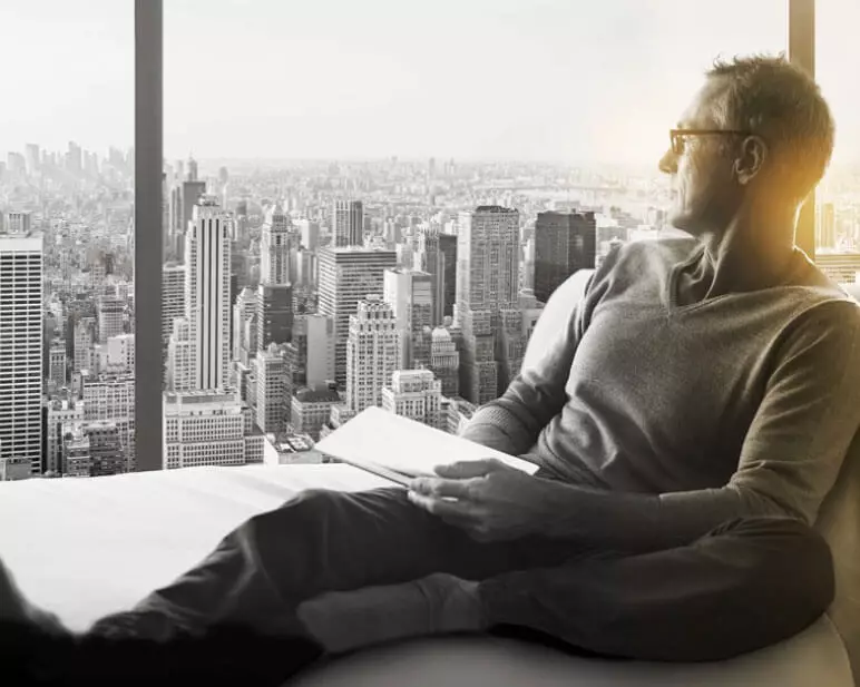 Male wearing eyeglasses staring out of window