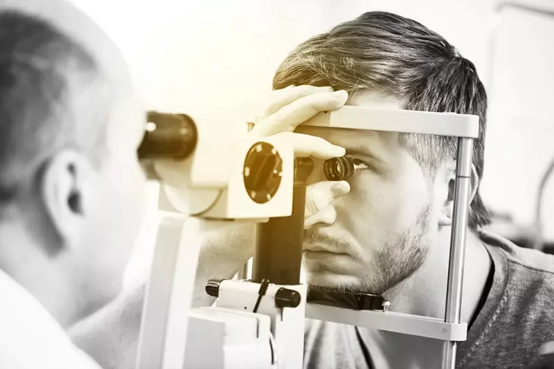Male having an eye test carried out by a male optician