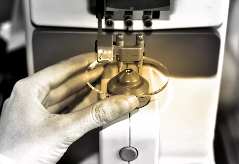 Female hand holding lens in a machine